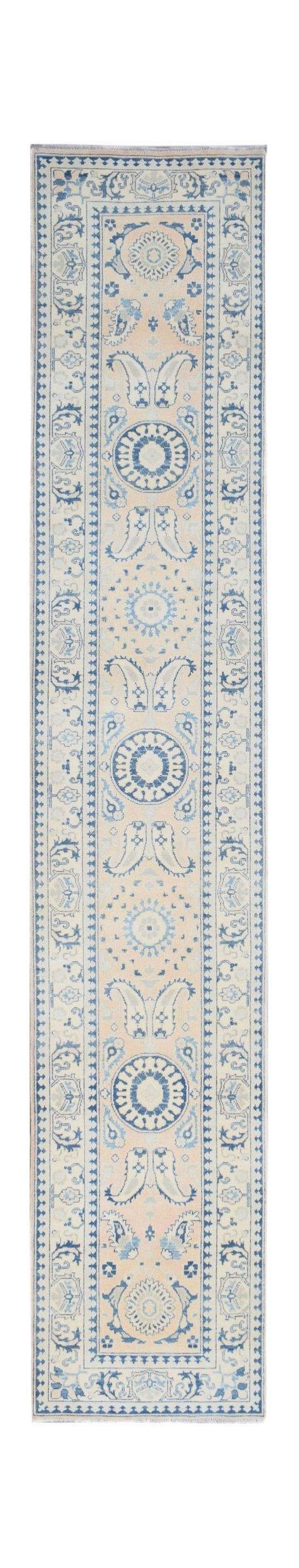 Handmade Afghan Kazakh runner rug featuring a beige field with blue floral and paisley motifs.