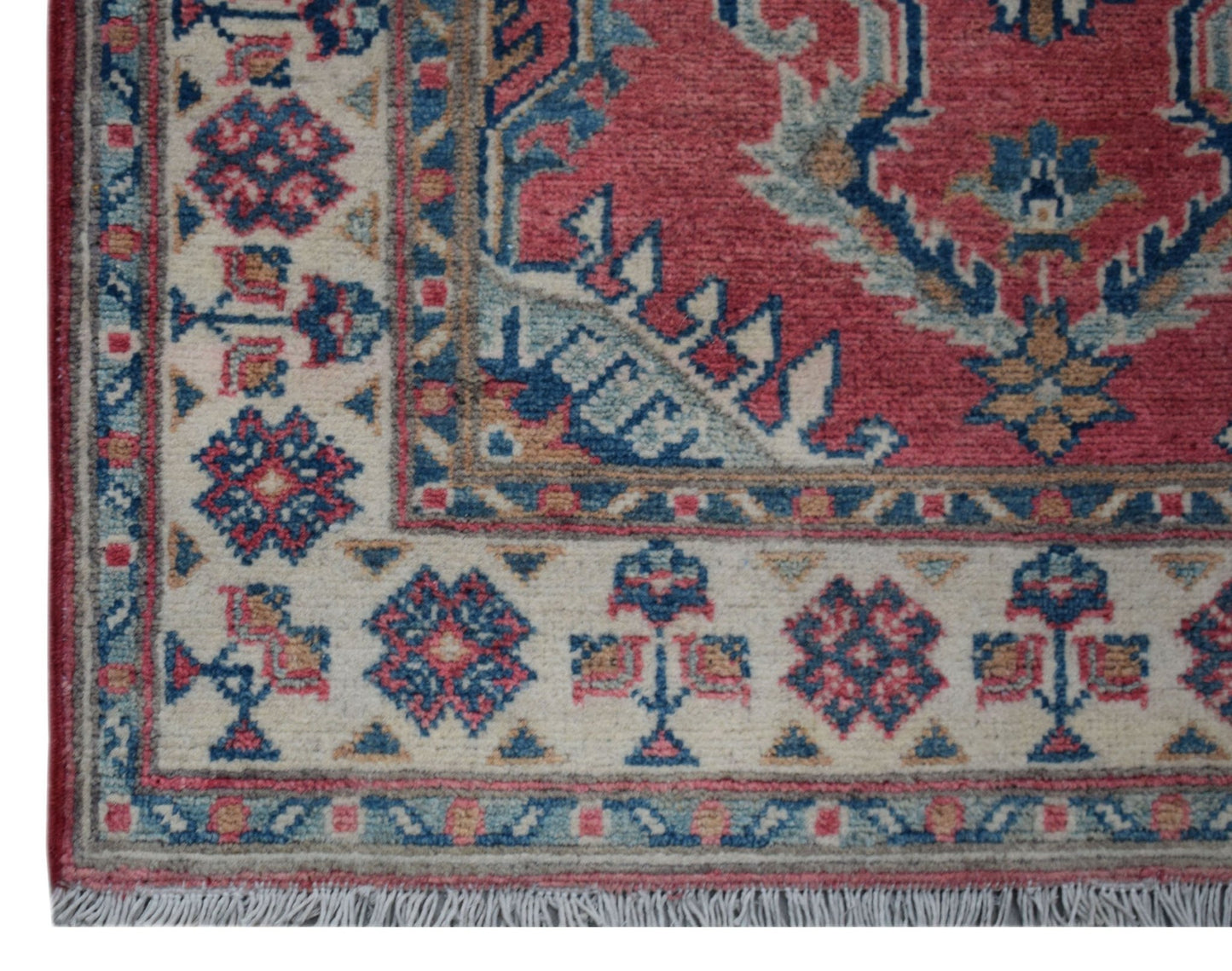 A handmade Afghan Kazakh runner featuring traditional geometric motifs in red, blue, and cream.