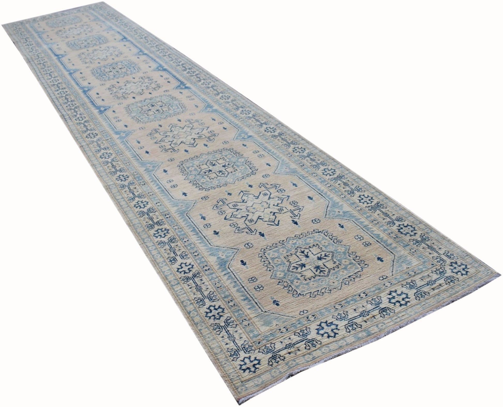 A long, handmade Afghan Kazakh runner rug featuring a beige field with blue geometric medallions.