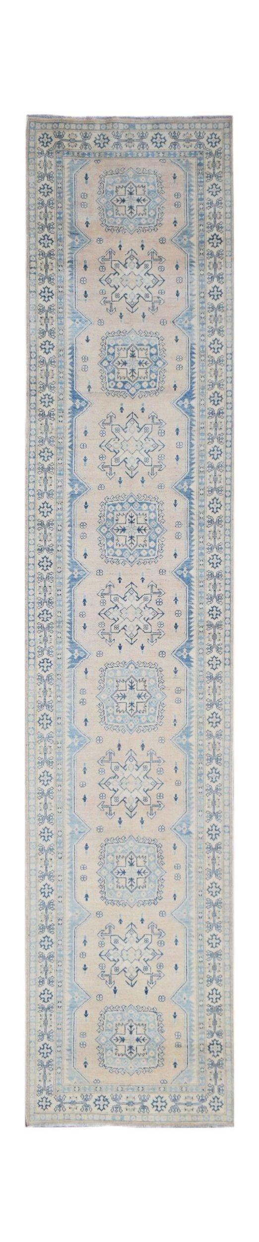 Handmade Afghan Kazakh runner rug featuring a beige field with repeating blue geometric motifs.