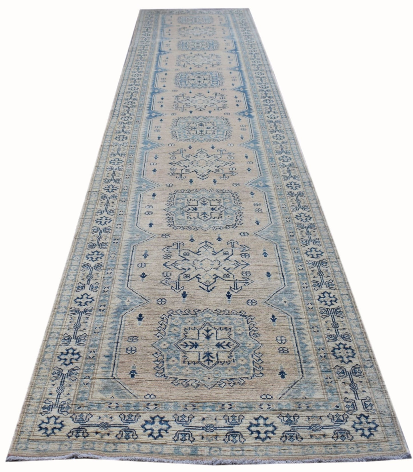 A handmade Afghan Kazakh runner rug featuring a repeating blue geometric pattern on a beige field.