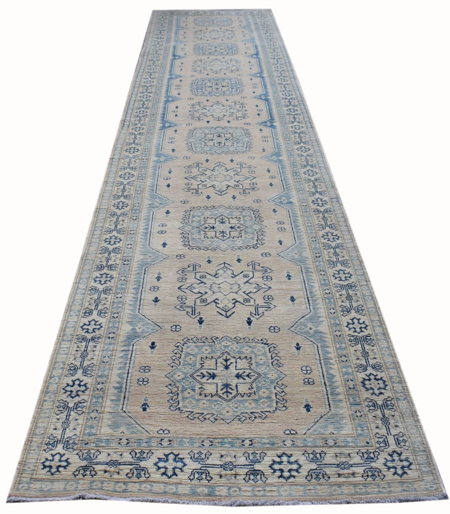A handmade Afghan Kazakh runner rug featuring a repeating blue geometric pattern on a beige field.