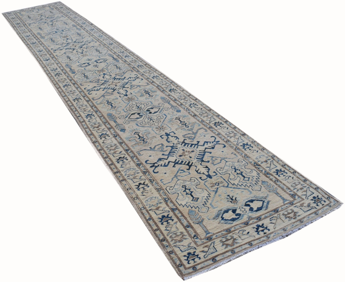 A long, handmade Afghan Kazakh runner rug featuring a beige field with blue and grey geometric motifs.