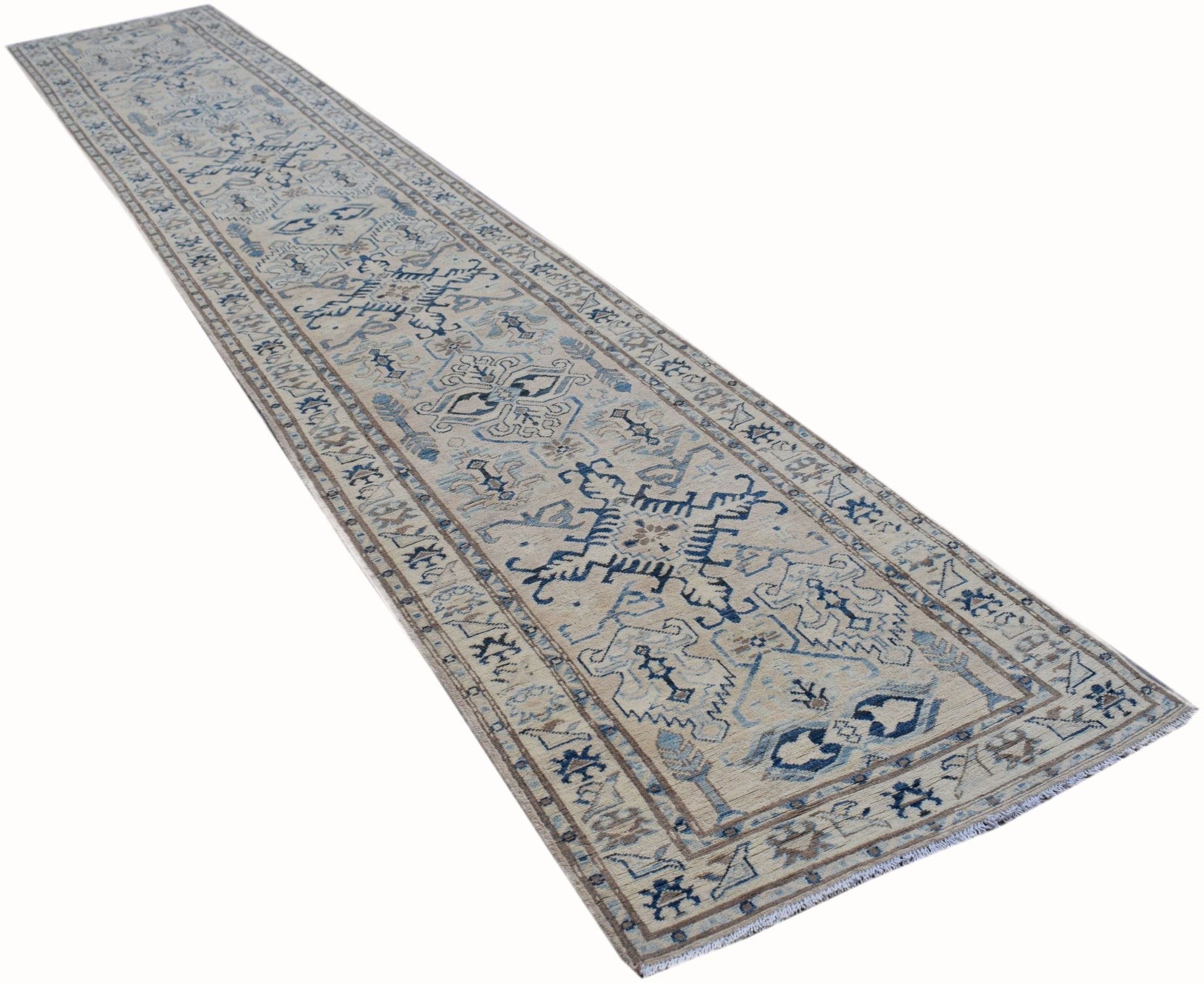 A long, handmade Afghan Kazakh runner rug featuring a beige field with blue and grey geometric motifs.