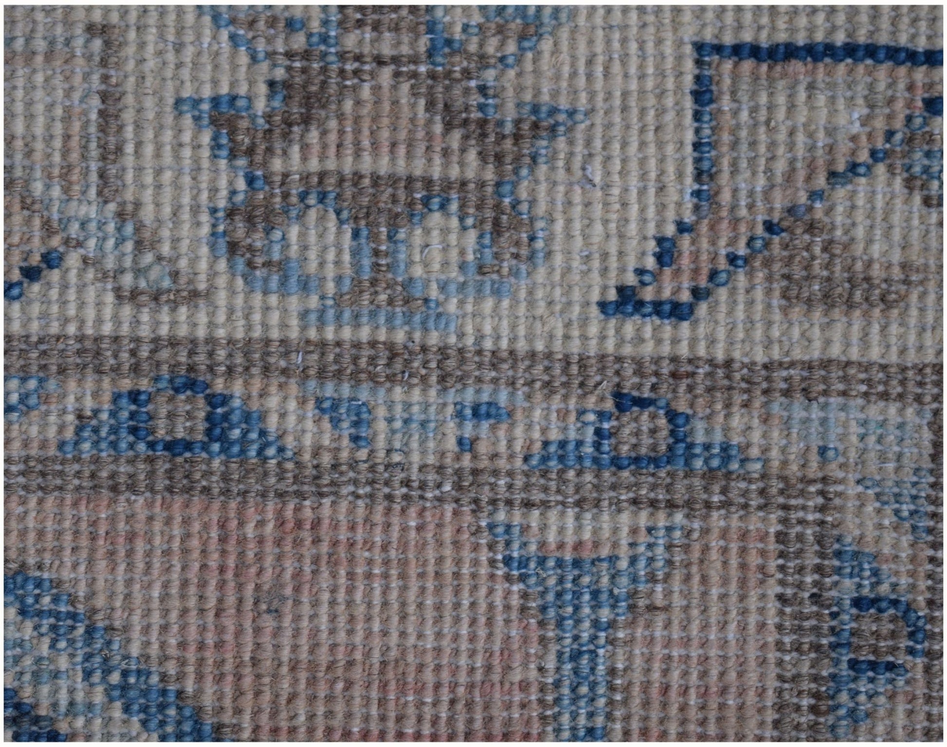 A close-up of an Afghan Kazakh runner rug featuring a geometric pattern in beige, blue, and grey.