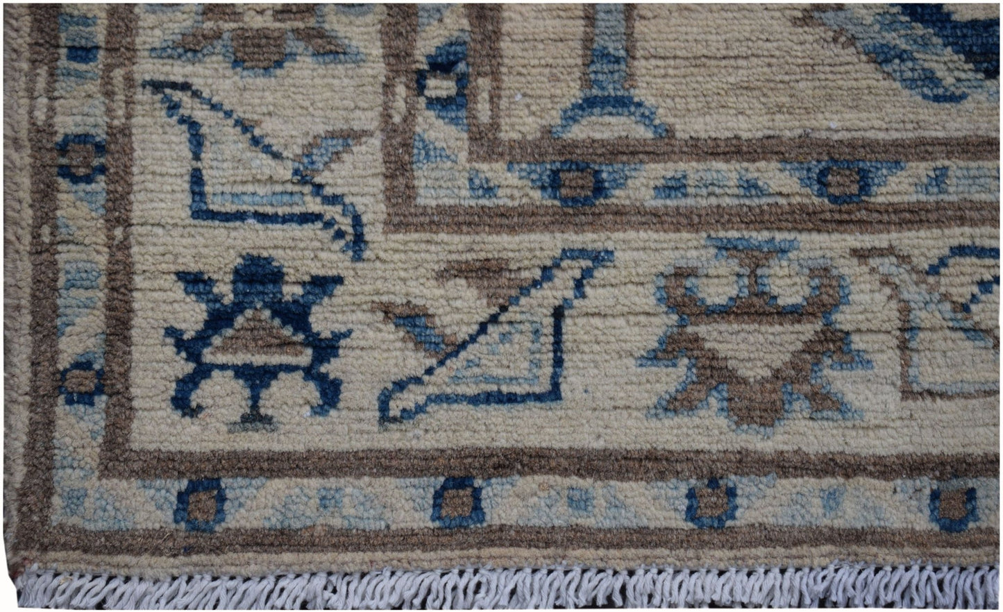 A handmade Afghan Kazakh runner featuring geometric tribal motifs in blue and brown on a beige base.