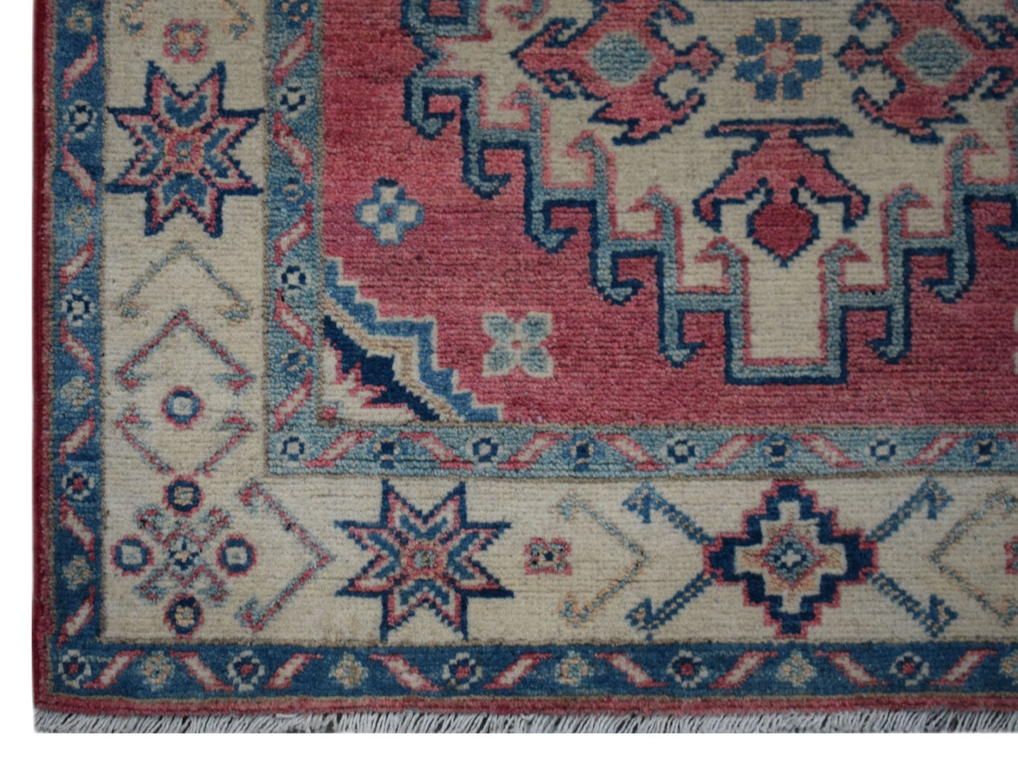 Handmade Afghan Kazakh runner featuring traditional geometric motifs in red, blue, and cream wool.