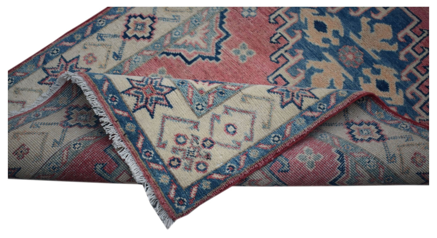 A handmade Afghan Kazakh runner featuring traditional geometric motifs in red, blue, and cream.