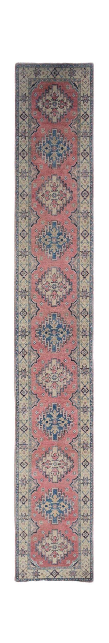 A handmade Afghan Kazakh runner rug featuring traditional geometric motifs in pink and blue.