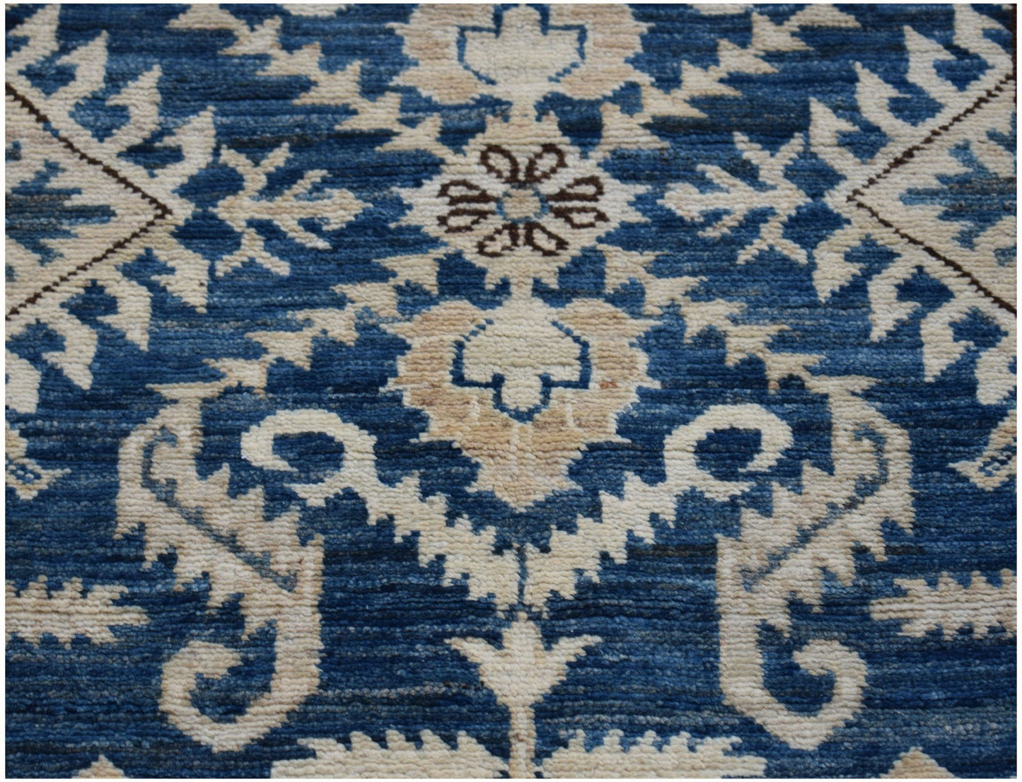 Handmade Afghan Kazakh runner rug featuring a traditional floral pattern in blue and beige wool.