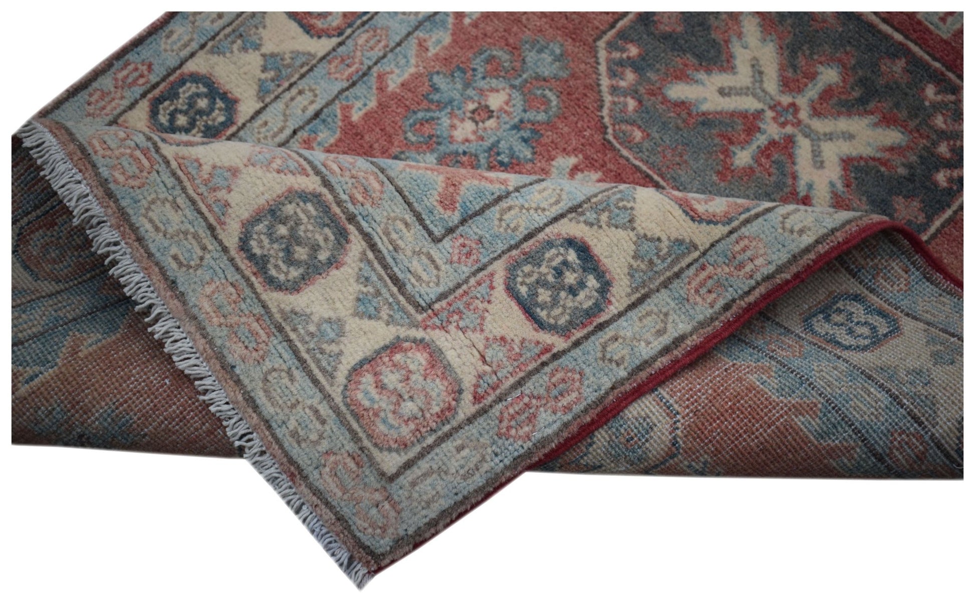 A handmade Afghan Kazakh runner featuring traditional geometric motifs in red, blue, and cream.