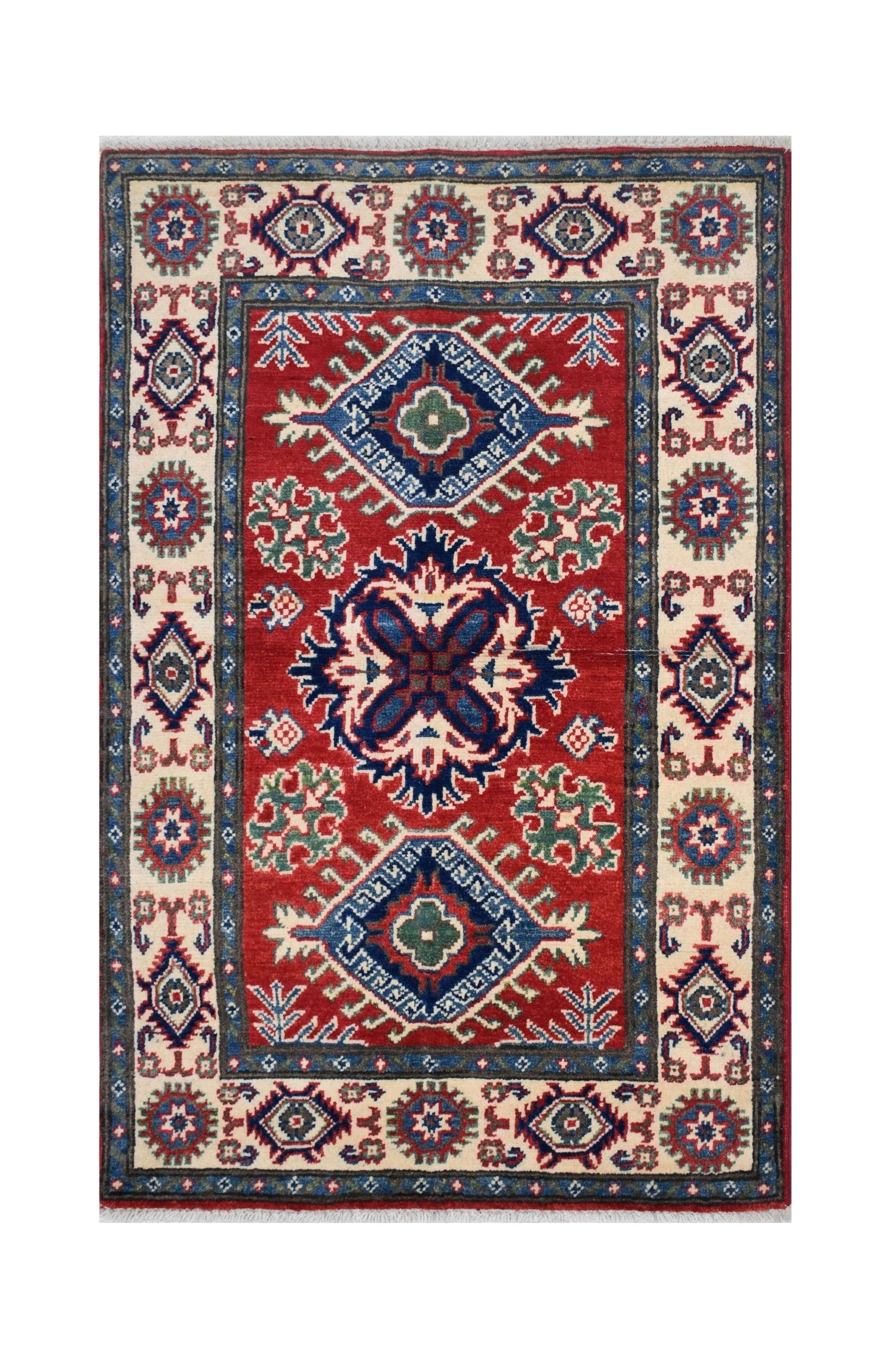 Handmade Afghan Kazakh rug featuring a red field with geometric medallions and a patterned border.