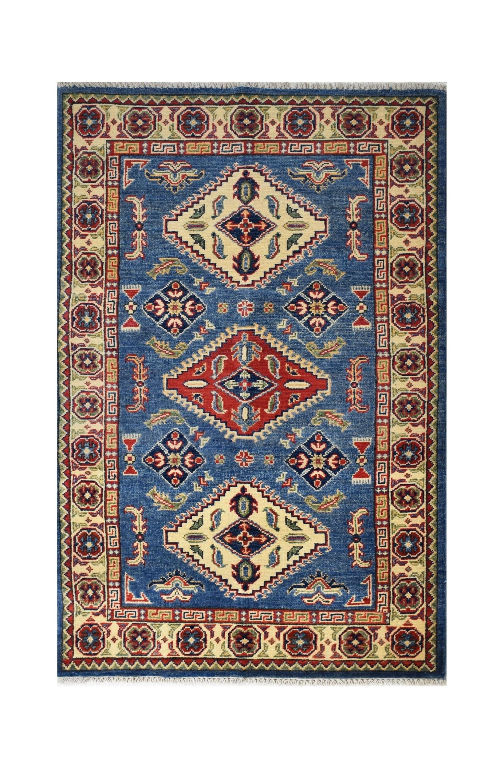 Handmade Afghan Kazakh rug featuring a blue field with geometric diamond motifs and a patterned border.