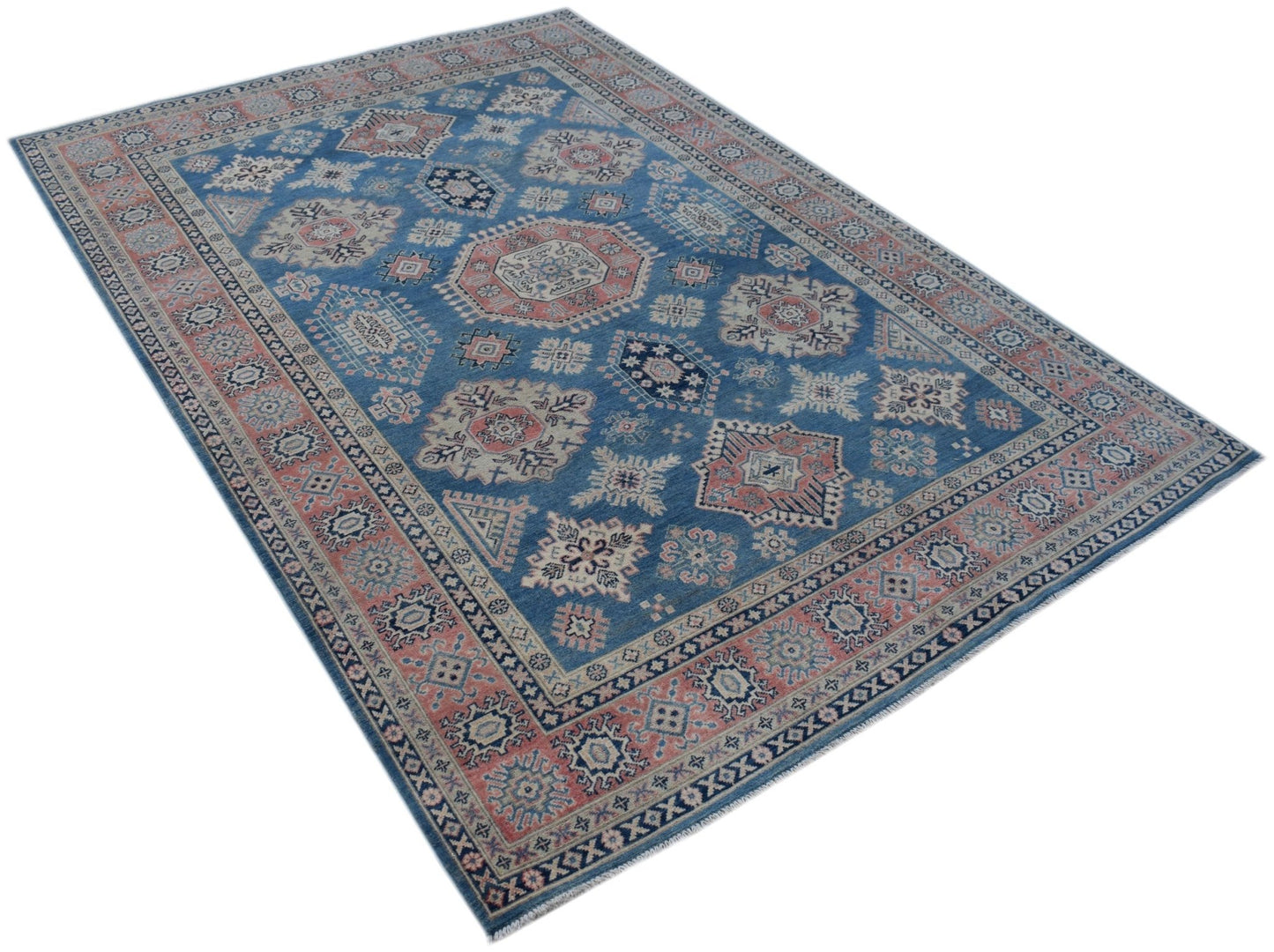 A handmade Afghan Kazakh rug featuring traditional geometric motifs in blue, pink, and cream.