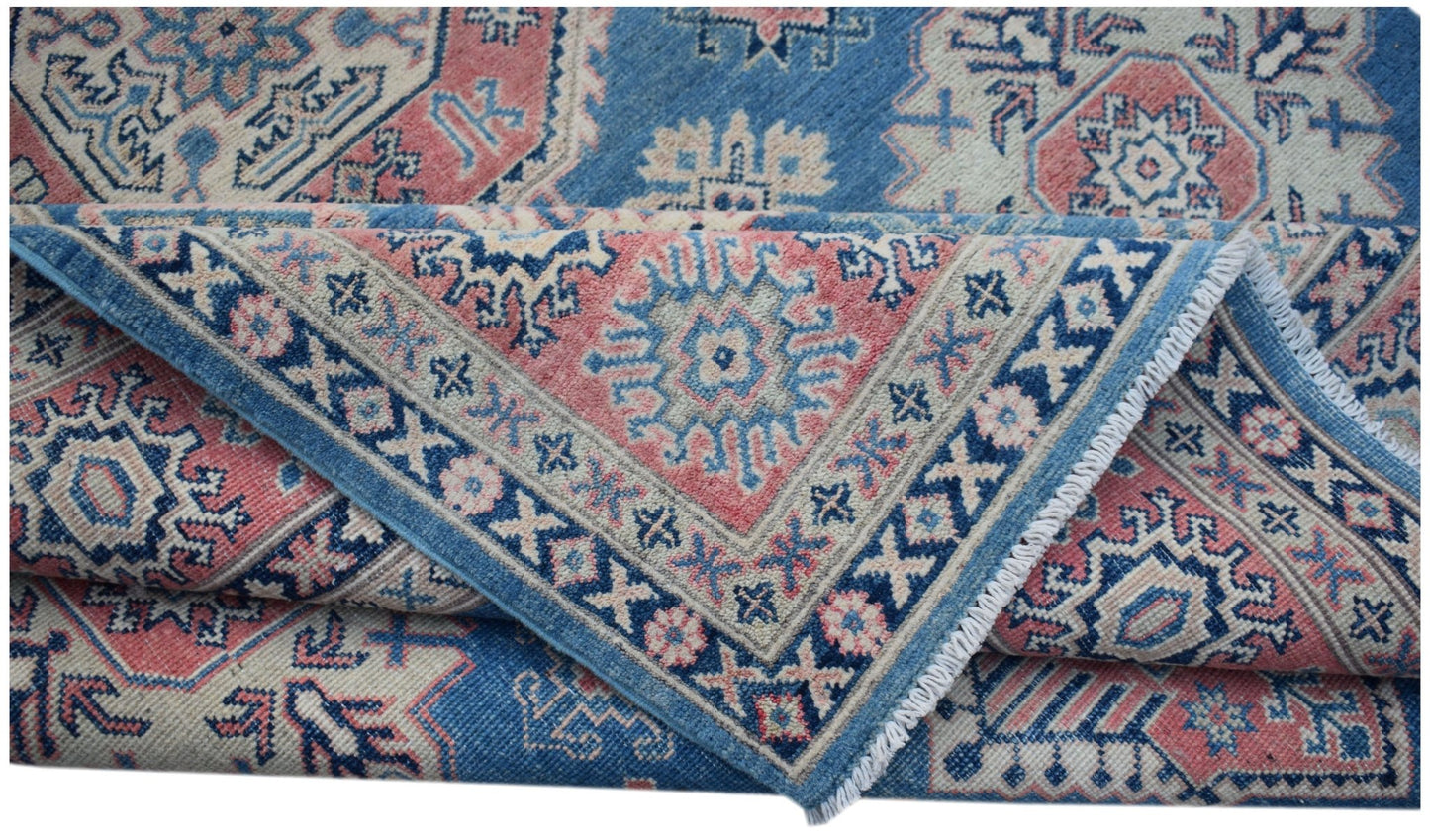 A handmade Afghan Kazakh rug featuring traditional geometric motifs in blue, pink, and cream.