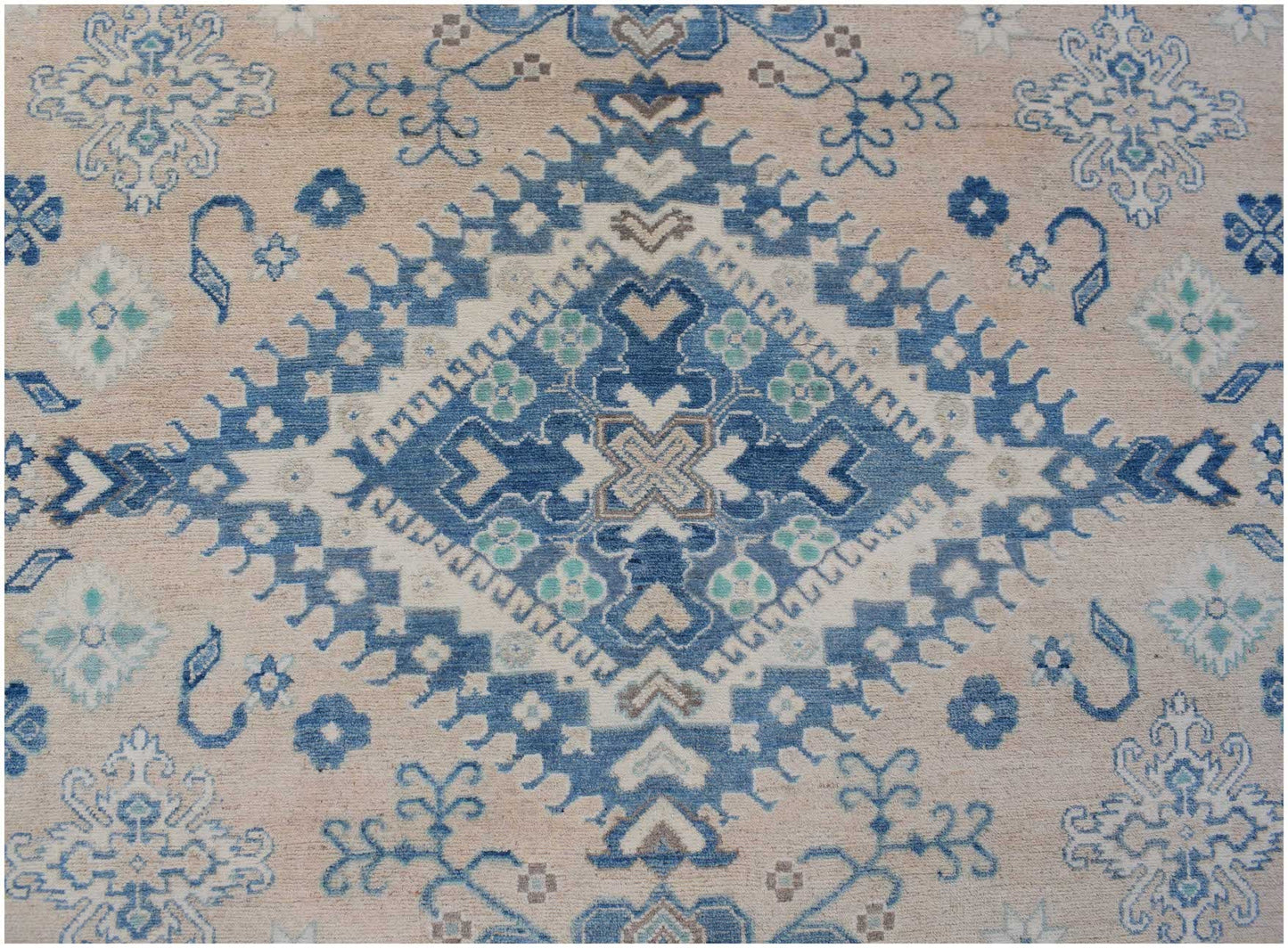 Handmade Afghan Kazakh rug featuring a central blue diamond medallion on a beige wool background.