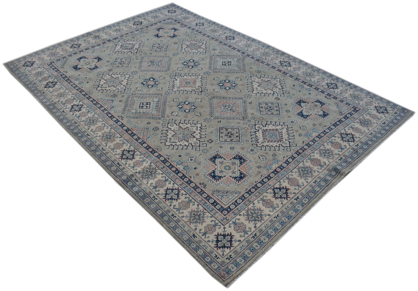 A handmade Afghan Kazakh rug featuring traditional geometric motifs in blue and pink on a grey base.