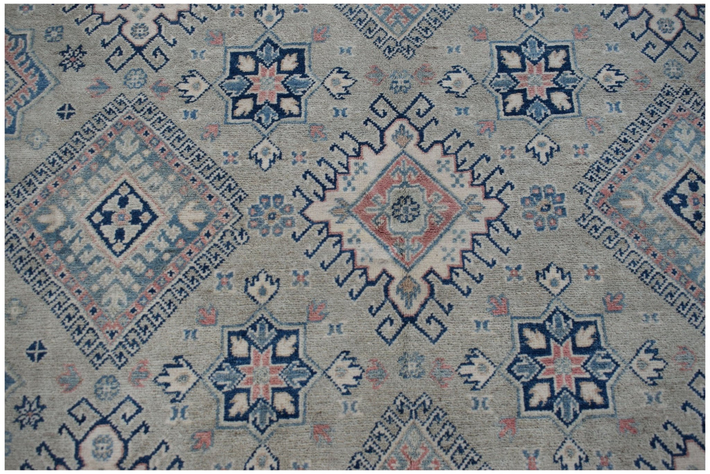 Handmade Afghan Kazakh rug featuring traditional geometric motifs in blue, pink, and cream tones.