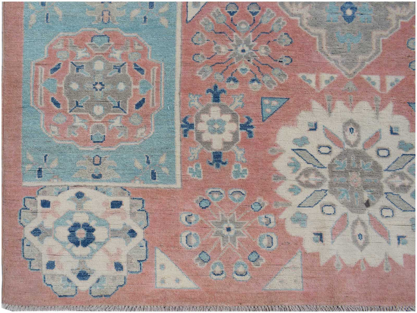Handmade Afghan Kazakh rug featuring geometric floral motifs in shades of pink, blue, and grey.