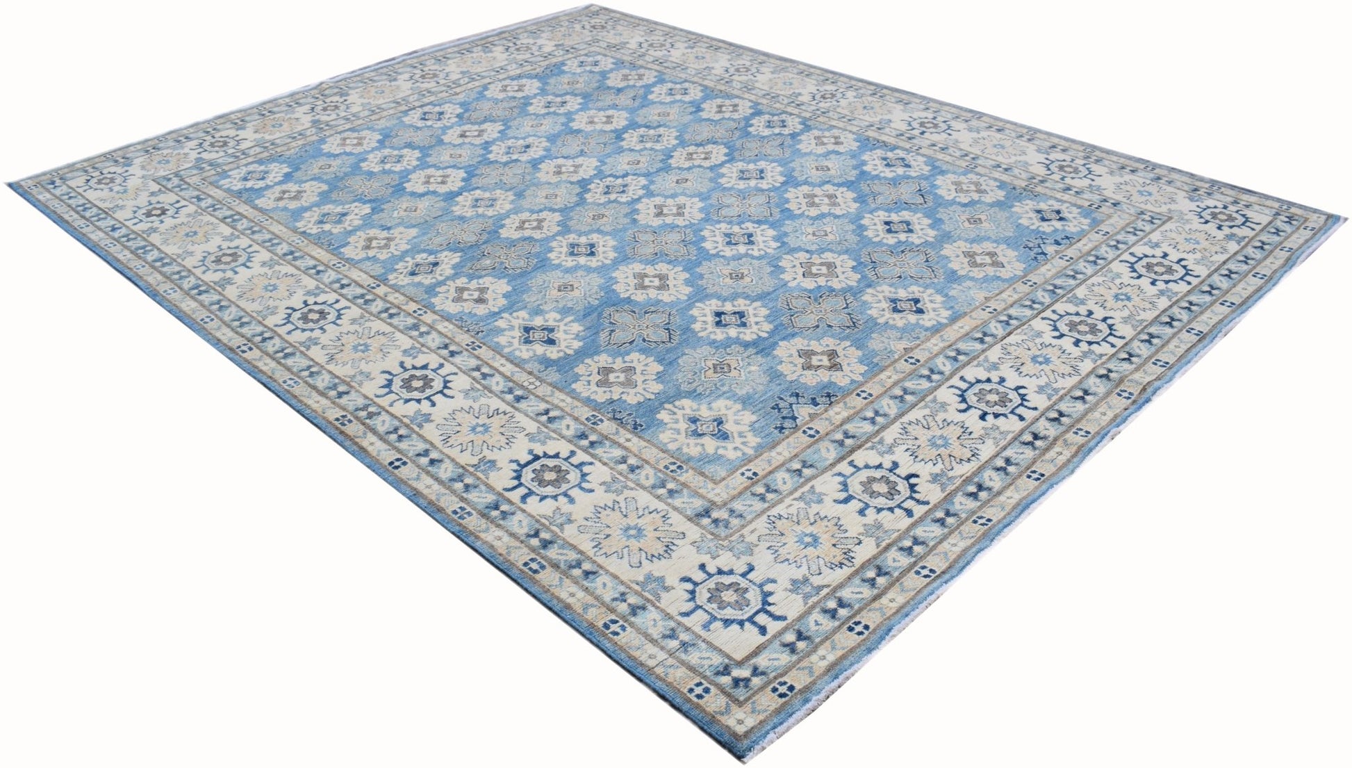 A handmade Afghan Kazakh rug featuring a repeating geometric pattern in shades of blue and beige.