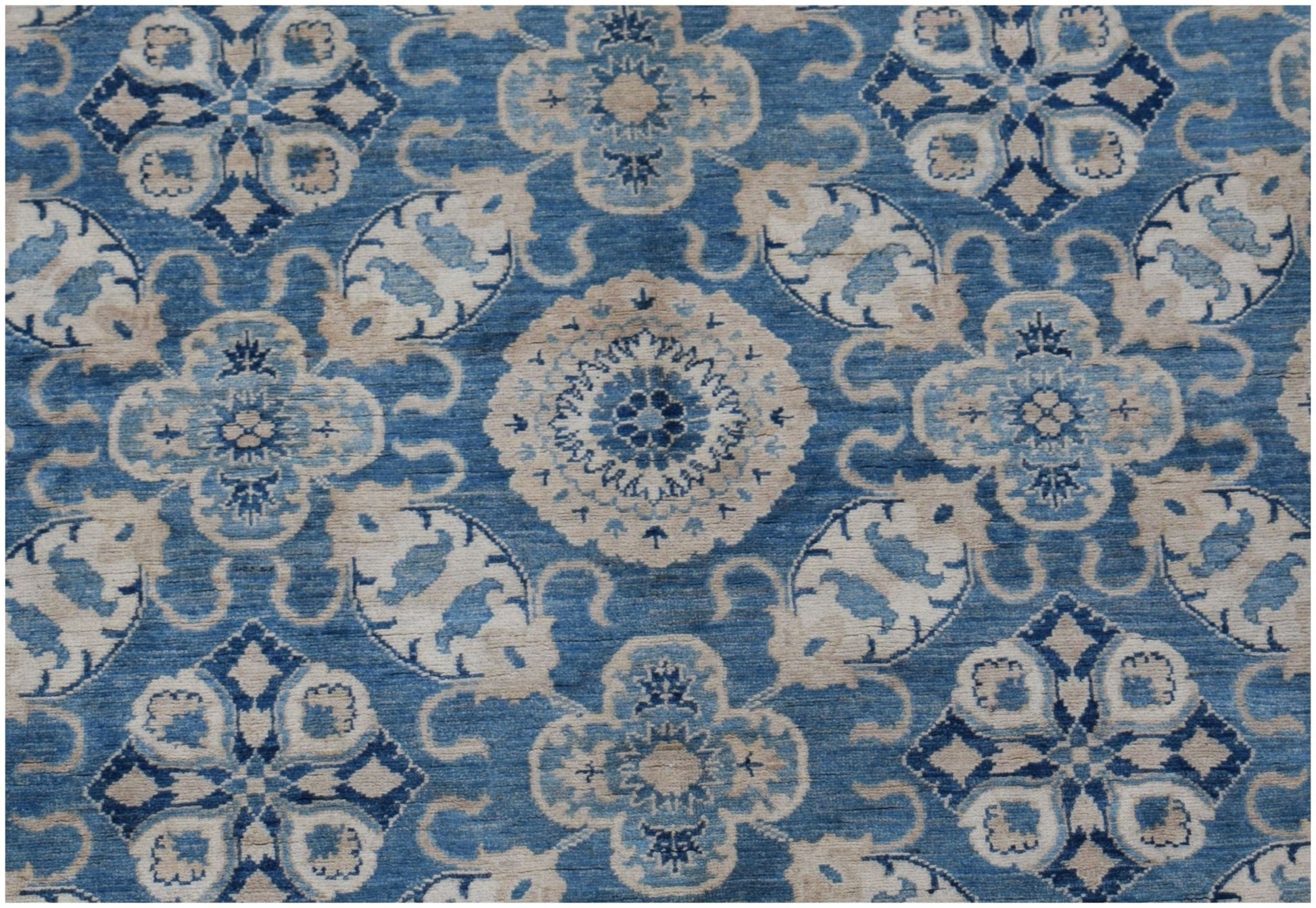 An Afghan Kazakh rug featuring a repeating blue and cream floral medallion pattern.