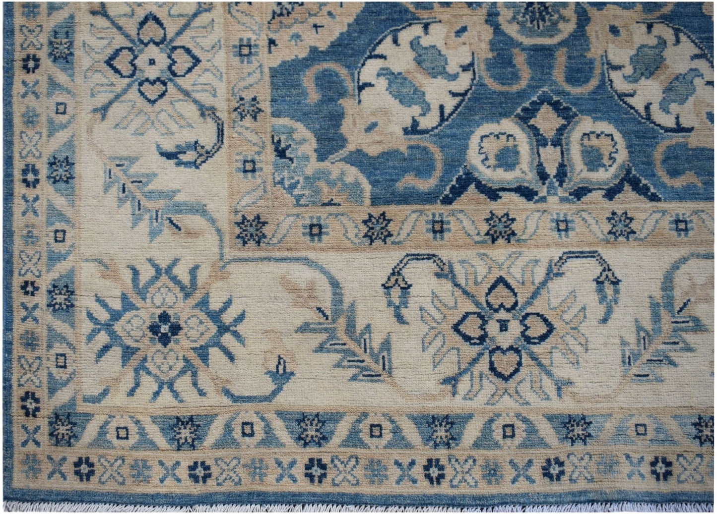Handmade Afghan Kazakh rug featuring traditional blue and cream floral geometric patterns.