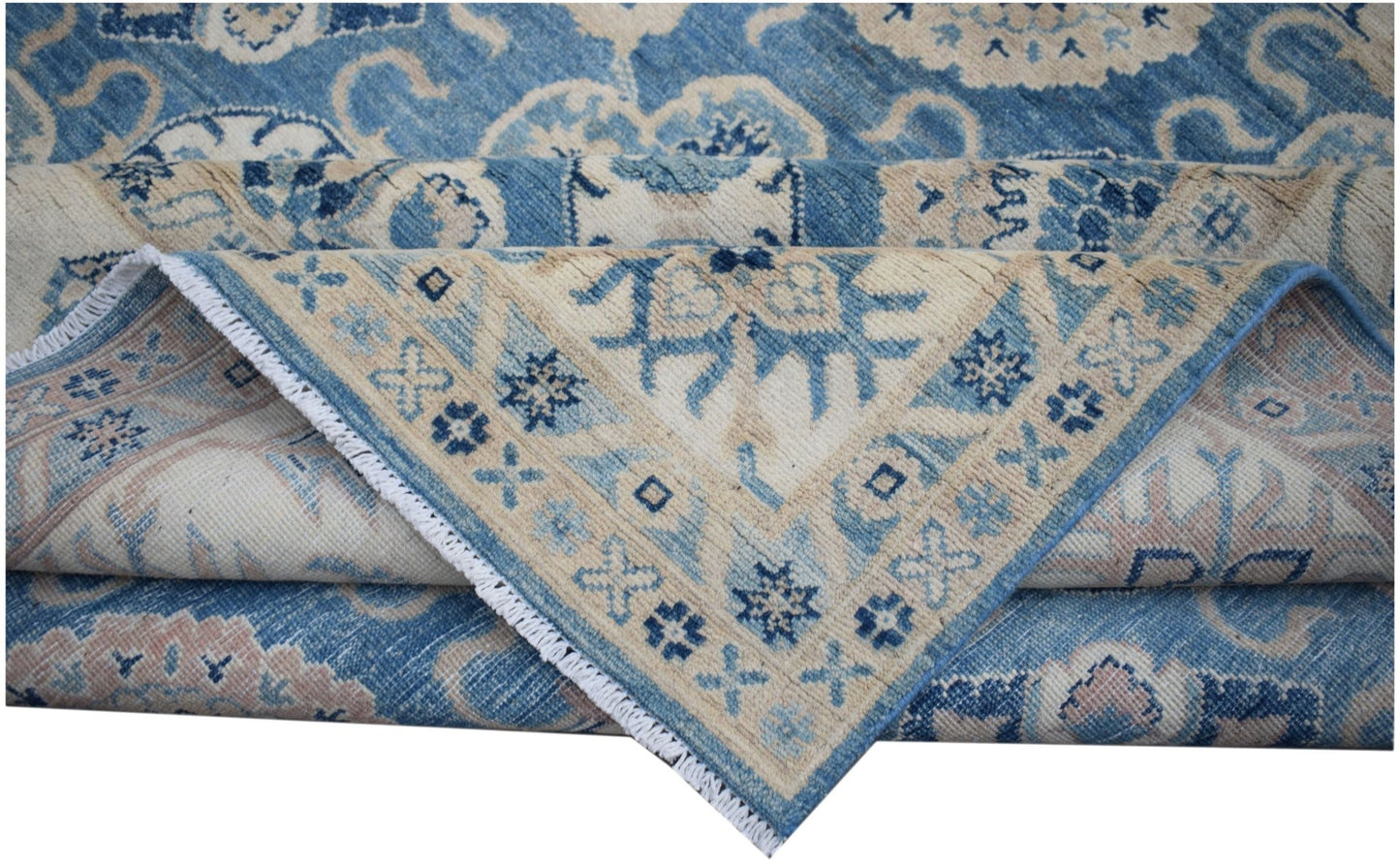A handmade Afghan Kazakh rug featuring traditional blue and cream geometric floral patterns.