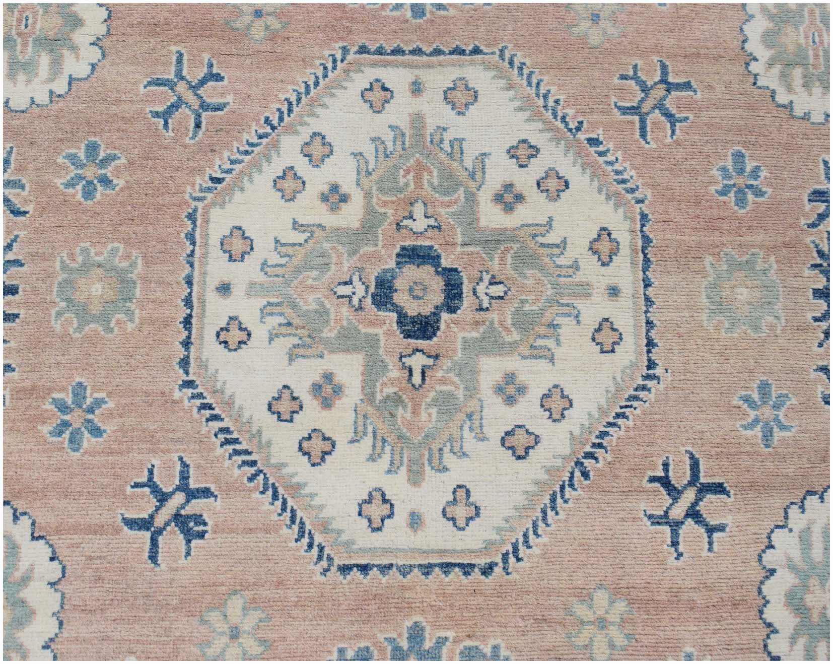 Handmade Afghan Kazakh rug featuring a central geometric medallion on a dusty pink background.