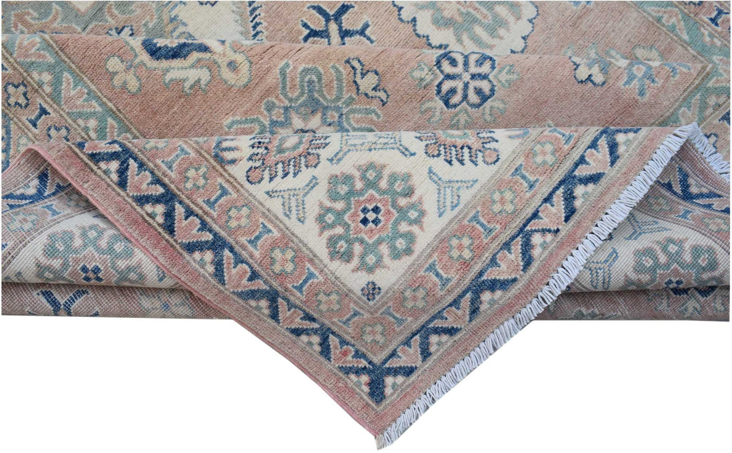 A folded Afghan Kazakh rug featuring traditional geometric motifs in blue, cream, and dusty pink.