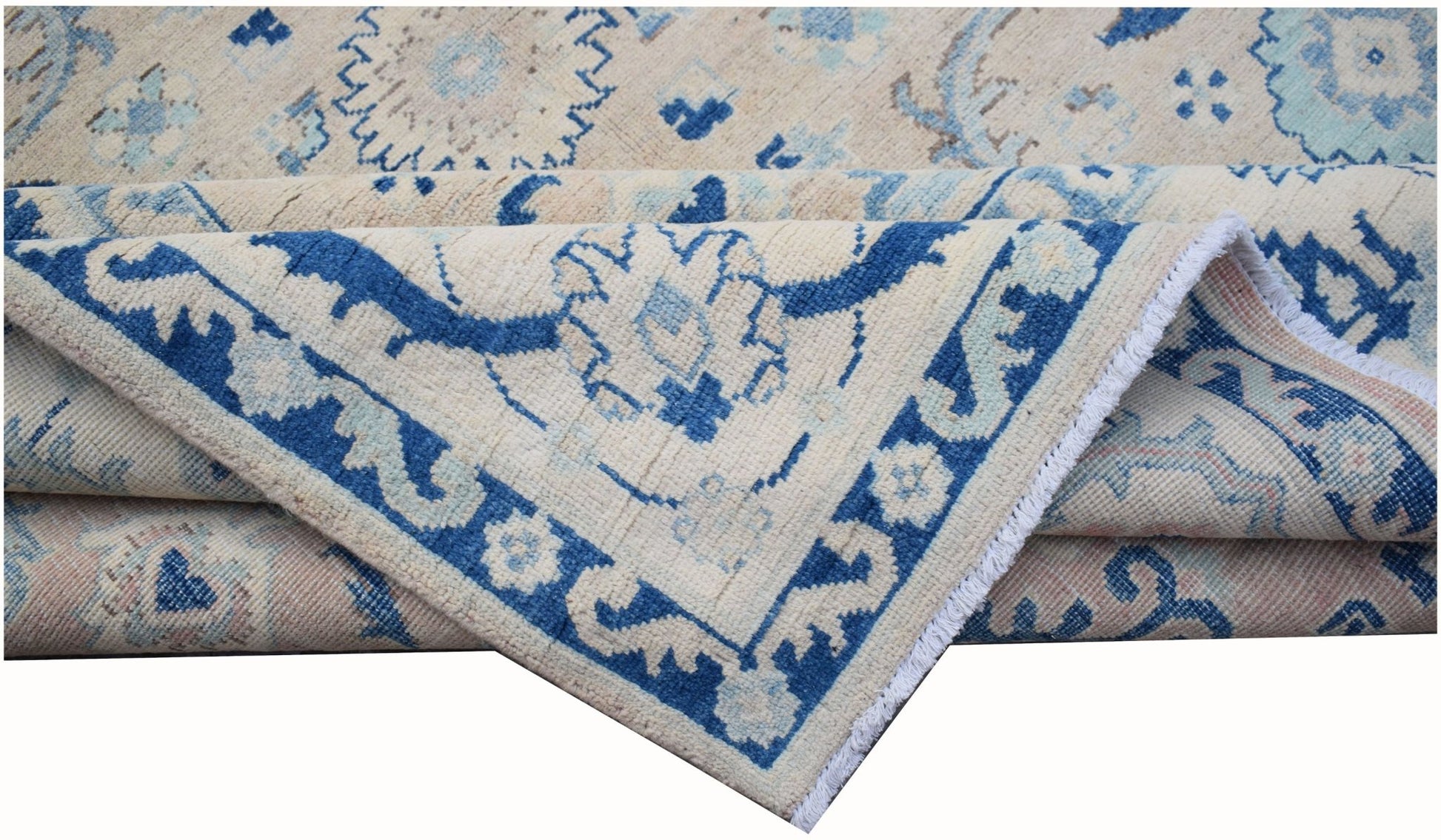 A handmade Afghan Kazakh rug featuring traditional blue and cream geometric patterns.