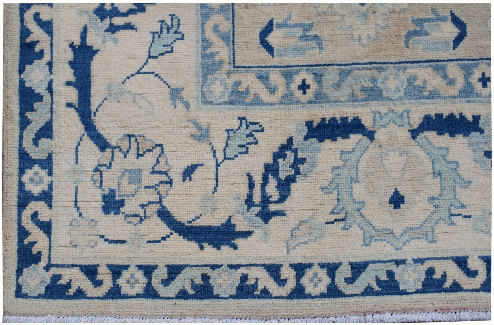 A handmade Afghan Kazakh rug featuring traditional blue and cream floral patterns.