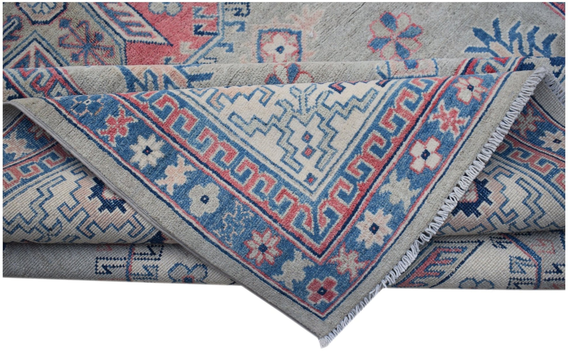 A handmade Afghan Kazakh rug featuring traditional geometric motifs in blue, pink, and cream wool.