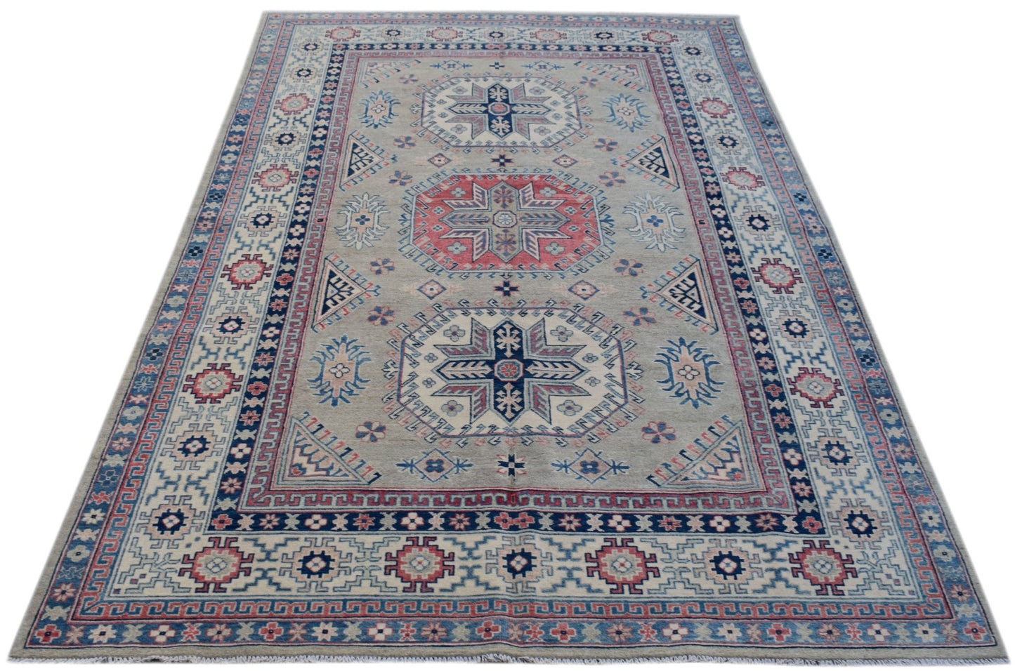 Handmade Afghan Kazakh rug featuring traditional geometric motifs in blue, red, and cream tones.