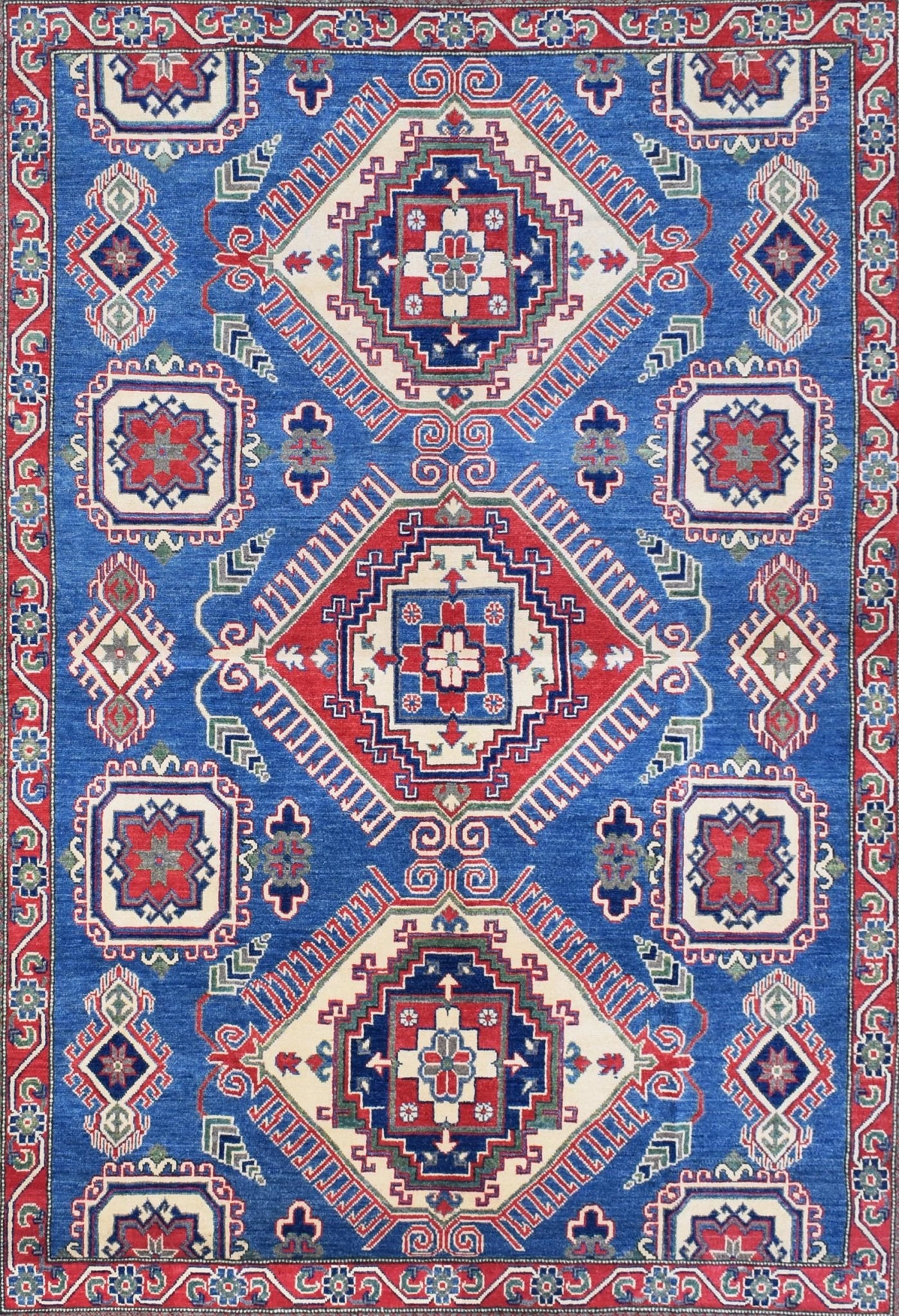 Handmade Afghan Kazakh rug featuring a geometric pattern in blue, red, and cream wool.