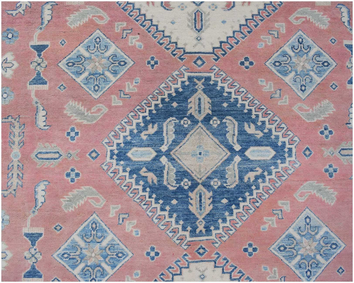 Handmade Afghan Kazakh rug featuring a geometric blue and cream pattern on a dusty pink background.