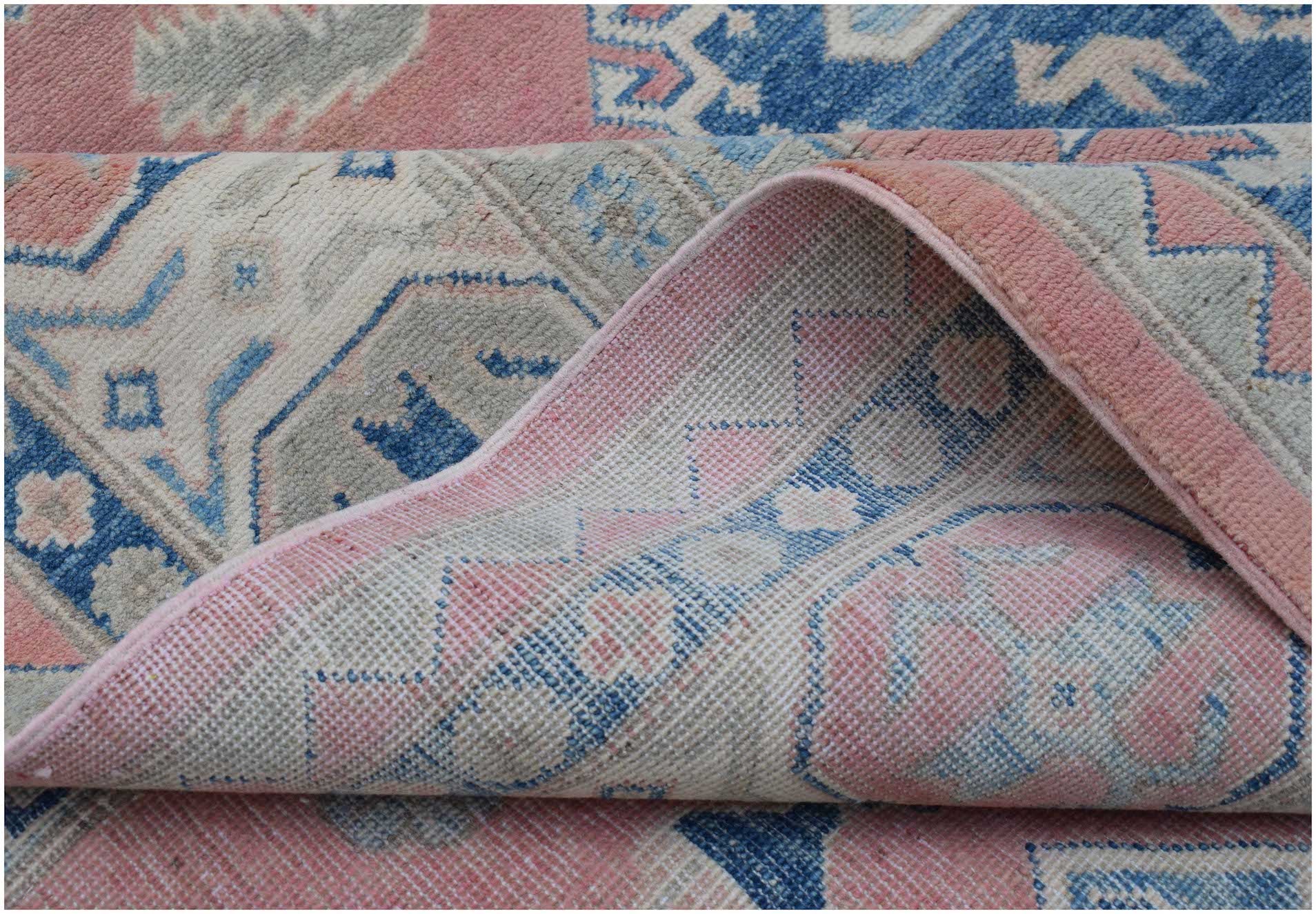 A handmade Afghan Kazakh rug featuring traditional geometric motifs in pink, blue, and cream.