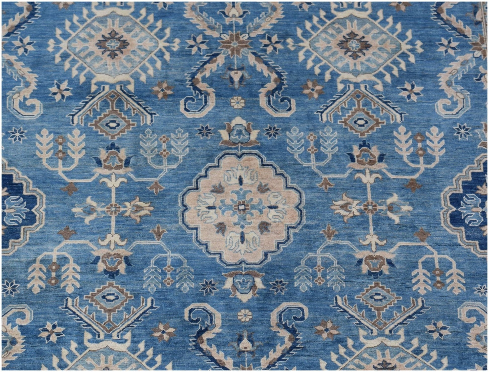 Handmade Afghan Kazakh rug featuring a geometric floral pattern in shades of blue and beige.