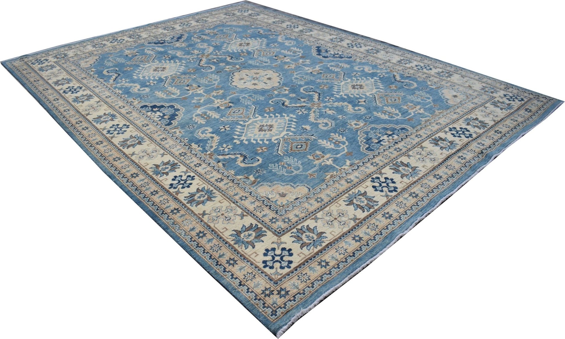 A handmade Afghan Kazakh rug featuring a blue field with intricate beige and grey geometric motifs.