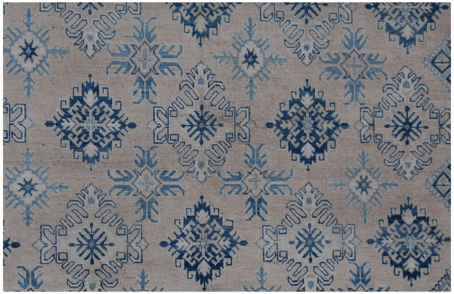 Handmade Afghan Kazakh rug featuring a repeating blue and cream geometric snowflake pattern.