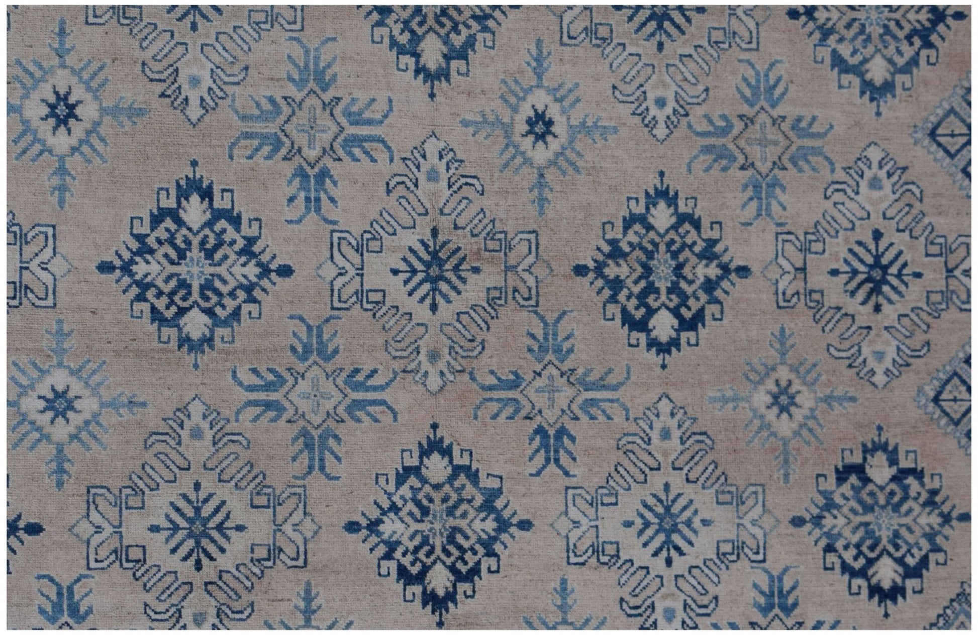 Handmade Afghan Kazakh rug featuring a repeating blue and cream geometric snowflake pattern.