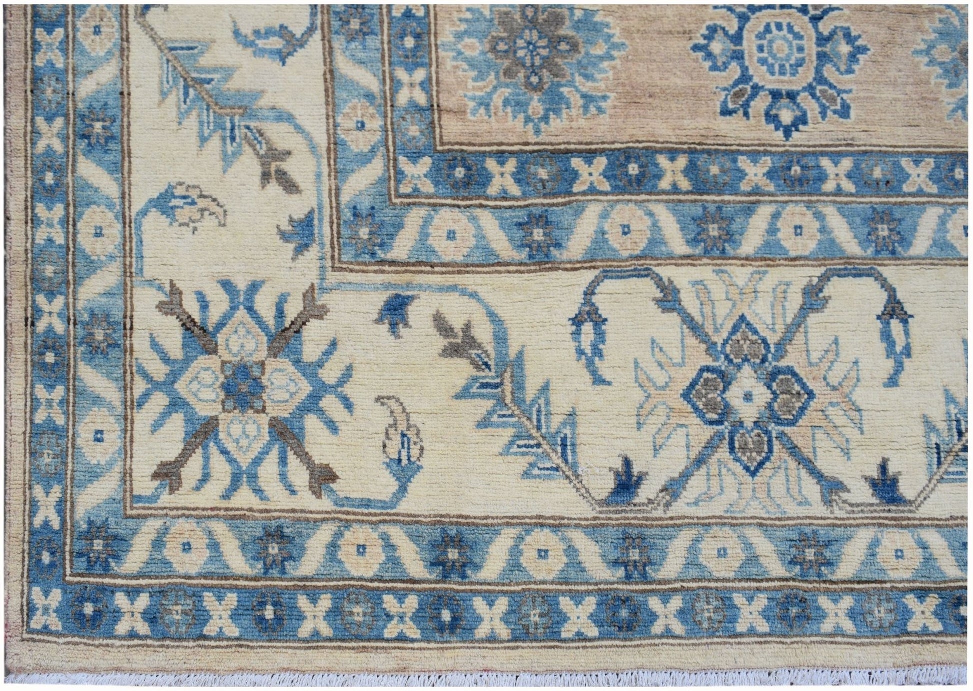 A handmade Afghan Kazakh rug featuring traditional blue and beige floral patterns.