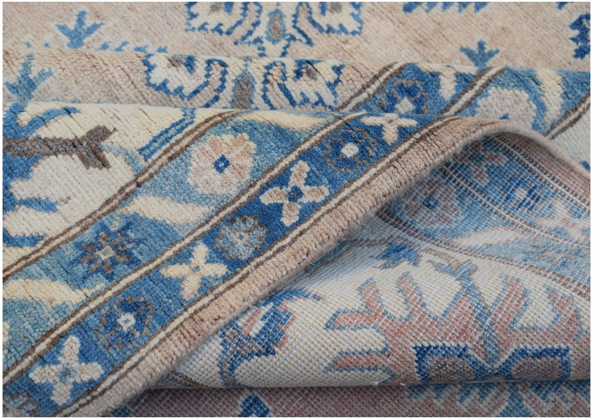 A handmade Afghan Kazakh rug featuring traditional blue and beige geometric patterns.