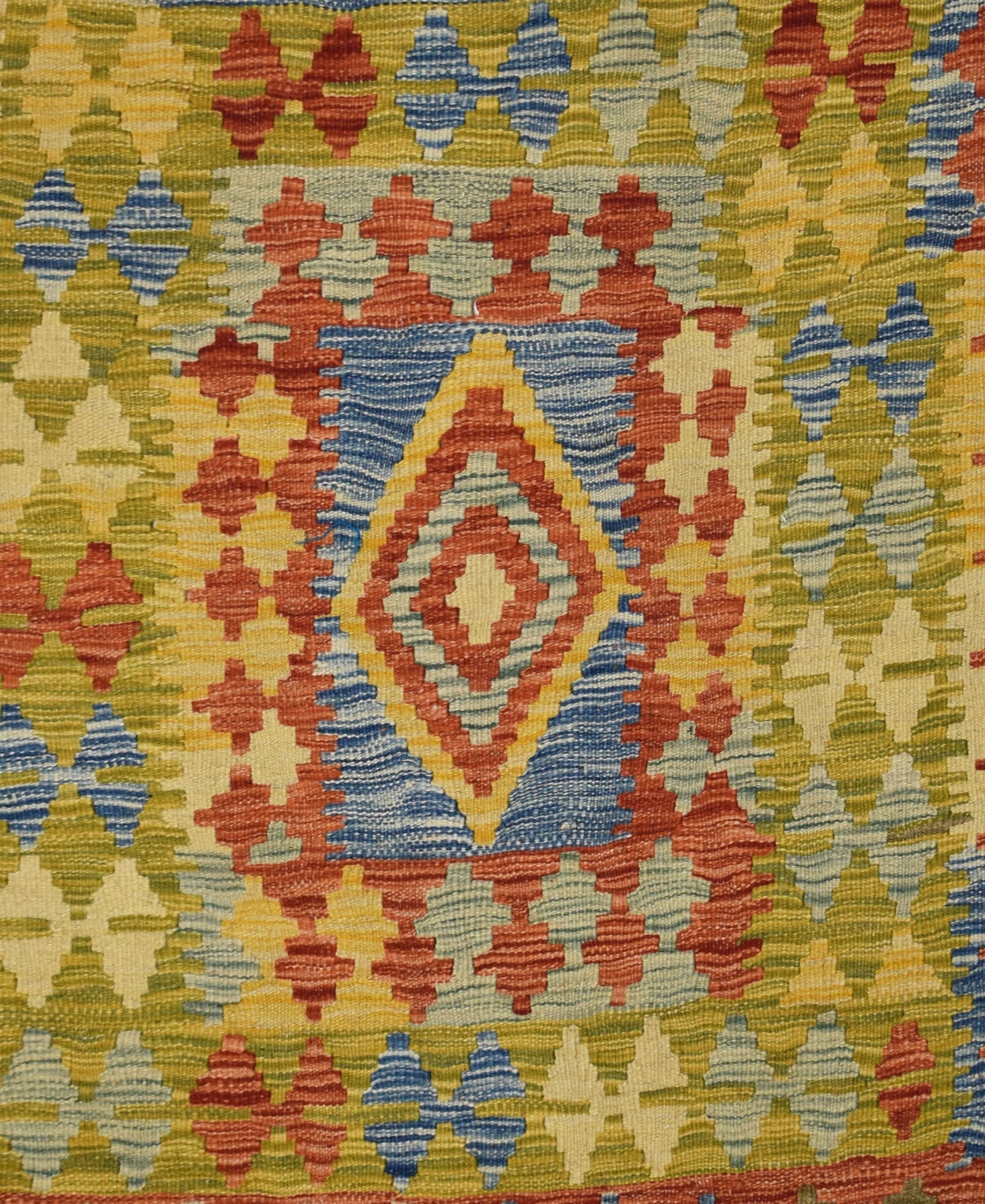 Handmade Afghan Maimana kilim rug featuring a geometric diamond pattern in vibrant wool colors.