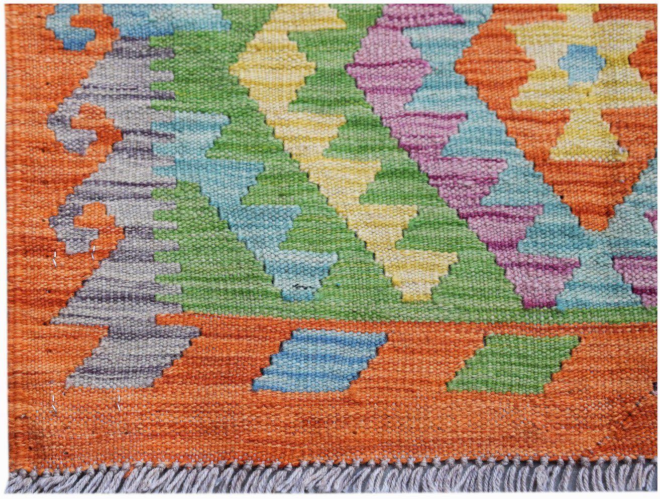 Handwoven Afghan Maimana kilim rug featuring a vibrant geometric pattern in wool.
