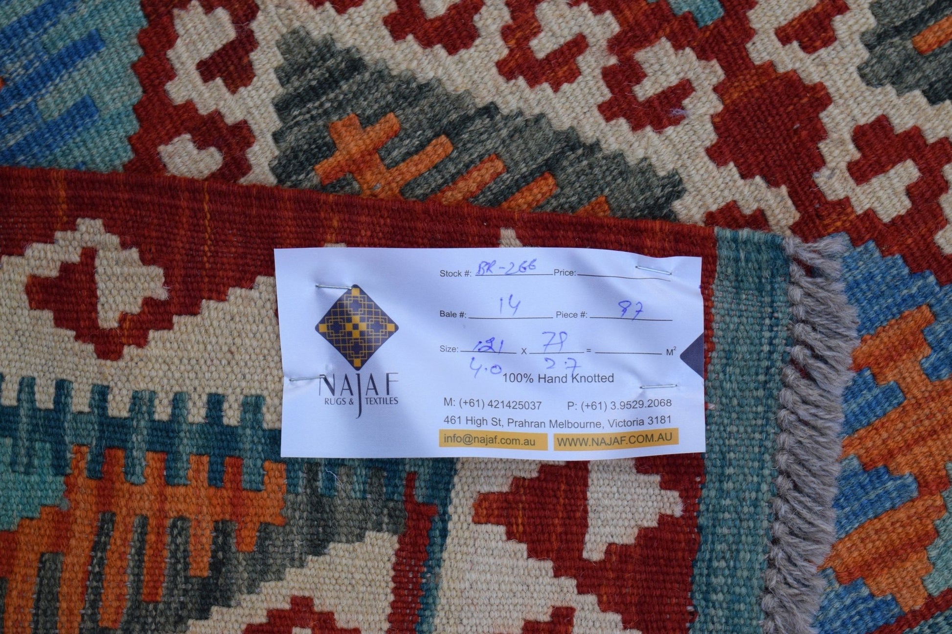 A handwoven Afghan Maimana Kilim rug featuring a geometric pattern in red, blue, and orange.
