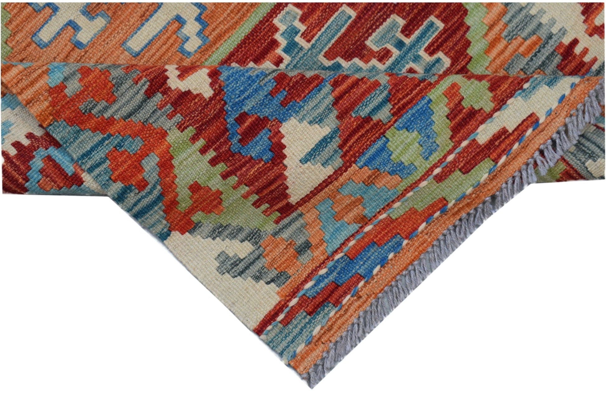 A handwoven Afghan Maimana kilim rug featuring a geometric pattern in red, blue, and green wool.