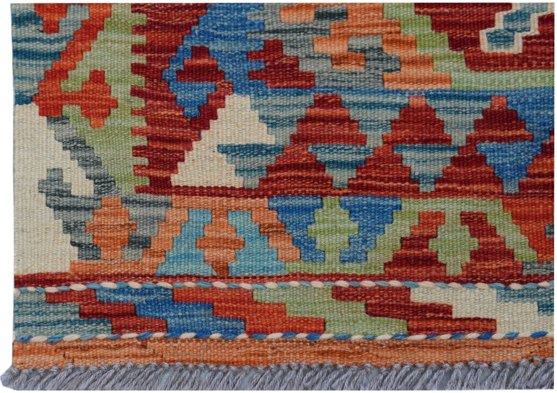 A handmade Afghan Maimana kilim featuring a vibrant geometric pattern in red, blue, and green wool.