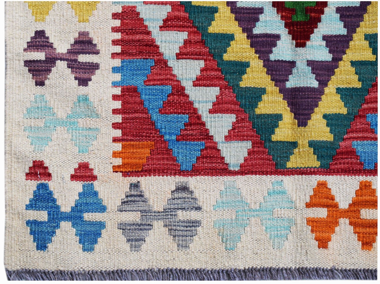 Handwoven Afghan Maimana kilim featuring a geometric pattern in vibrant, multi-colored wool.