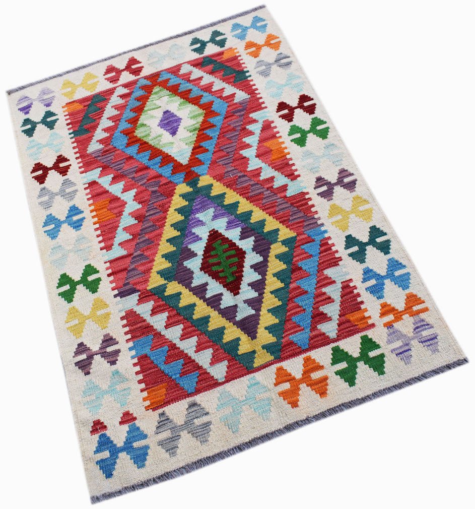 Handwoven Afghan Maimana kilim rug featuring a colorful geometric diamond pattern on a cream base.