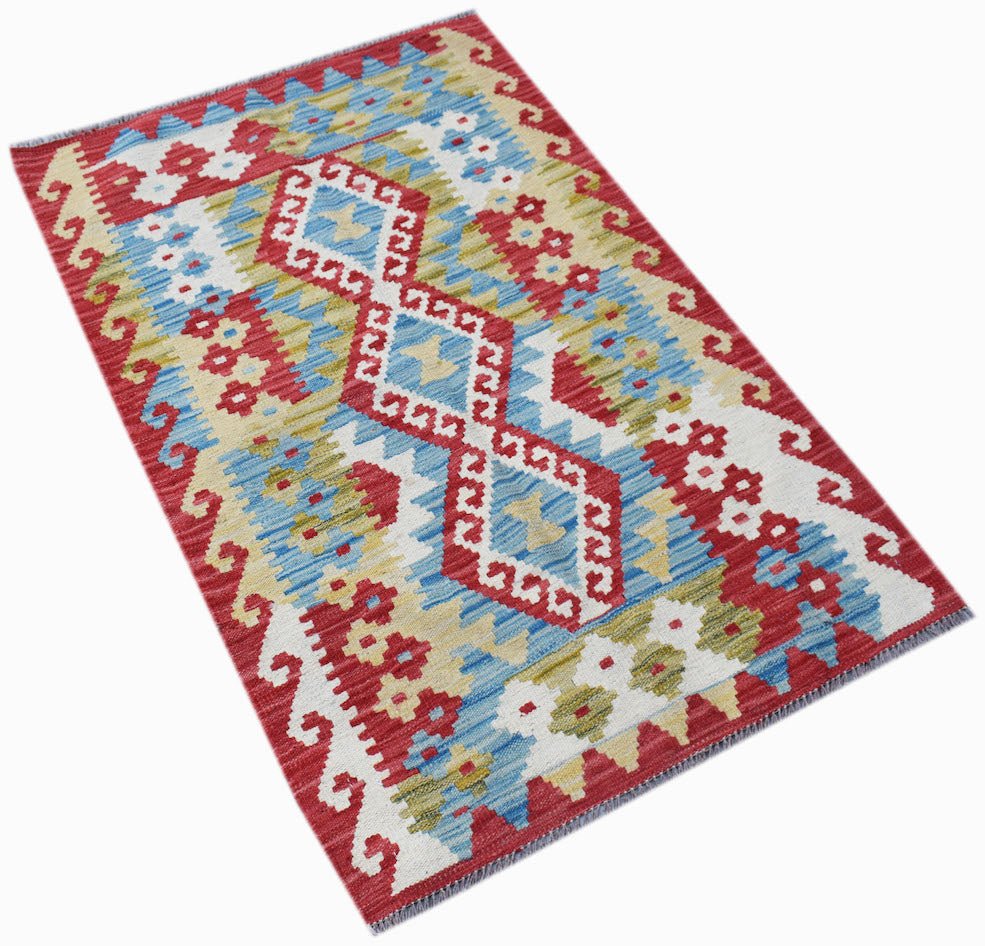 Handwoven Afghan Maimana kilim rug featuring a geometric pattern in red, blue, and cream wool.